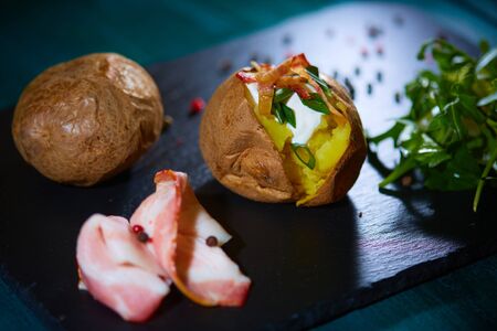 Baked potato with ham and grated cheesesの写真素材