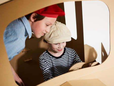 Creative children plays in cardboard car playhouse.の写真素材