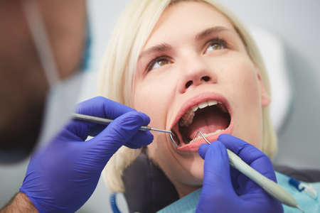 Young smiling woman with beautifiul teeth, having a dental inspectionの写真素材