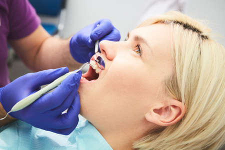 Young smiling woman with beautifiul teeth, having a dental inspectionの写真素材