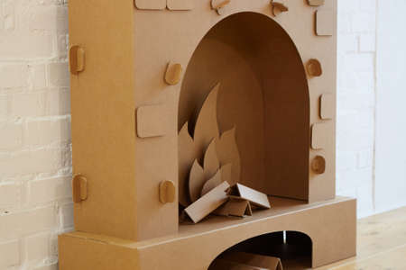 Cardboard fireplace. Closeup of firewood burning in fireの写真素材