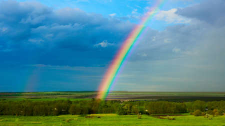 The Rainbow over a field after thunderstormの写真素材