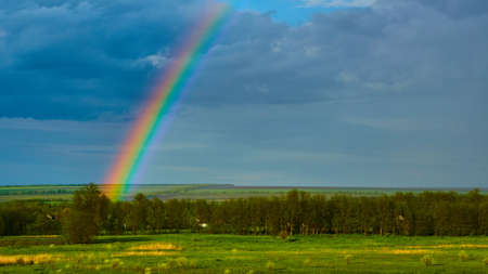 The Rainbow over a field after thunderstormの写真素材