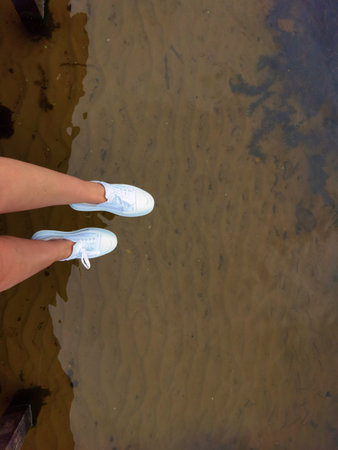 Woman legs above water on a dock, summer relaxの写真素材