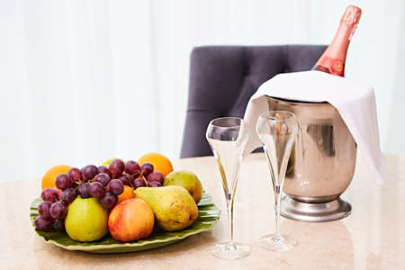 Champagne in a Hotel Room, Ice Bucket, Glasses and Fruits on a Plate - Honeymoon Conceptの写真素材