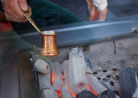 A turkish coffee pot on some wood burning with coffee inside.の写真素材