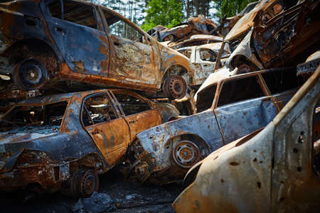 A lot of rusty burnt cars in Irpen, after being shot by the Russian military. Russias war against Ukraine. Cemetery of destroyed cars of civilians who tried to evacuate from the war zoneの写真素材