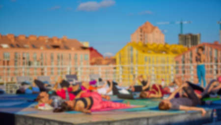 Blurred background of peoples playing yoga outdoorの写真素材