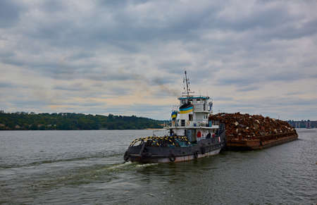 Transportation industry. Ship barge transports scrap metal and sand with gravel