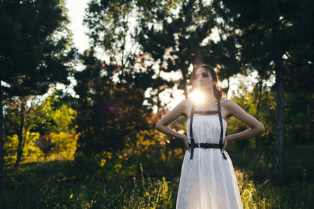 Portrait of a beautiful girl in a white dress at sunset.の写真素材