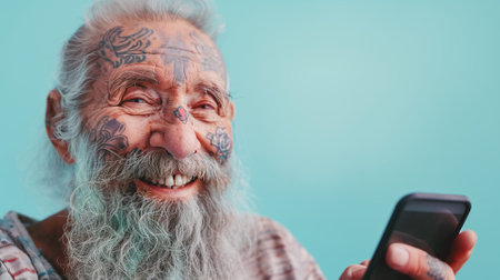Senior hipster man using smartphone. Trendy tattoo guy having fun with mobile phone technology. Modern Aging and joyful elderly lifestyle concept.の素材