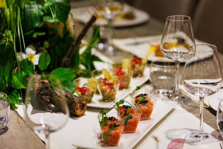 Exquisite gourmet salmon tartare appetizers elegantly presented in clear cups, garnished with black caviar and fresh microgreens, ideal for luxury events, cocktail parties, and high-end catering.の写真素材