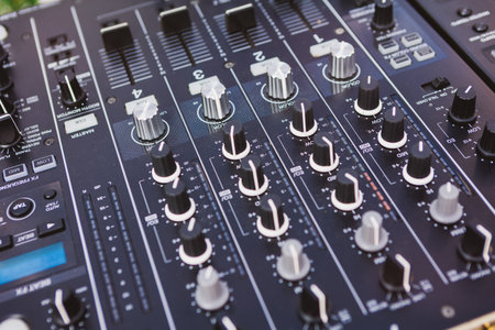 Close-up of a professional audio mixers faders and knobs