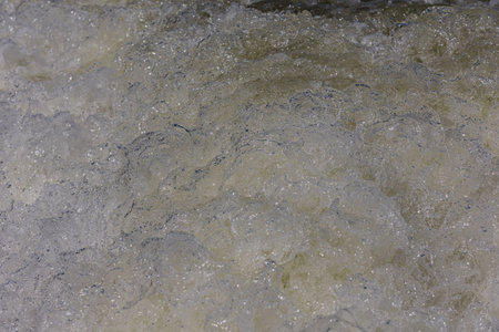 Turbulent water, showing churning foam, bubbles, and surface tension.の写真素材