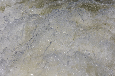 Turbulent water, showing churning foam, bubbles, and surface tension.の写真素材