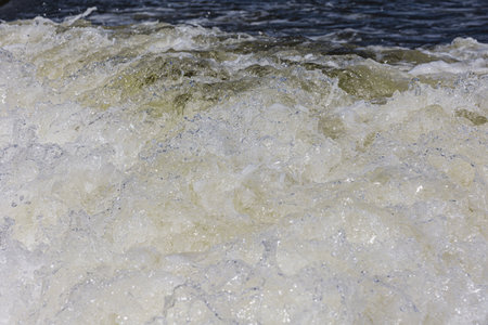Turbulent water, showing churning foam, bubbles, and surface tension.の写真素材