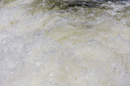 Turbulent water, showing churning foam, bubbles, and surface tension.の写真素材
