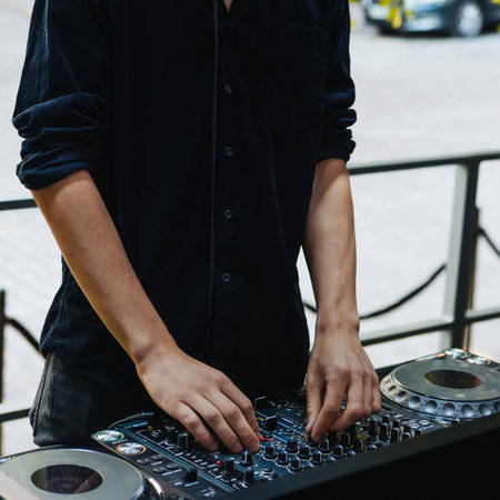 DJ hands mixing on a console. Concept for live music, modern lifestyle, creative passion, and party entertainmentの写真素材