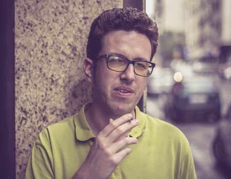 Man in green shirt smokingの写真素材