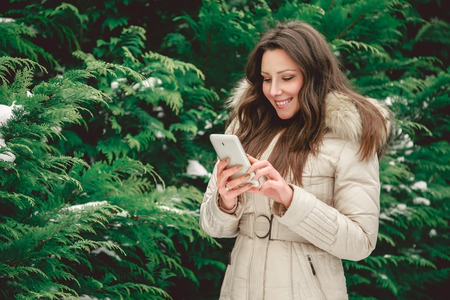 Girl in forest holding phoneの写真素材