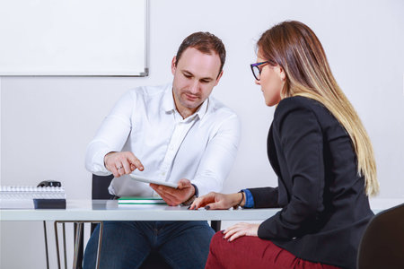 Businessman and businesswoman working with tabletの写真素材