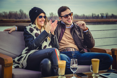 Couple sitting by the river and laughingの写真素材