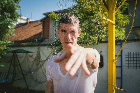 Wet man pointing at cameraの写真素材