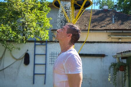Handsome man showering outsideの写真素材