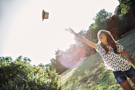 Happy girl throws hat in airの写真素材