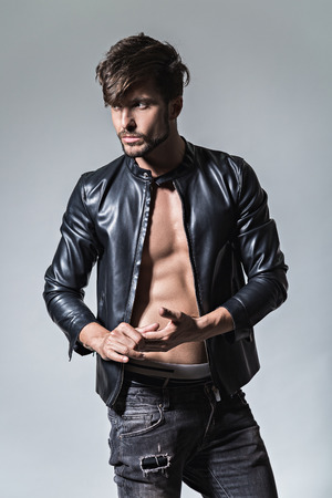 Man with attitude in leather jacket and jeans looking to the sideStudioの写真素材