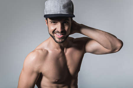 Shirtless man smiling wearing hat. Studioの写真素材