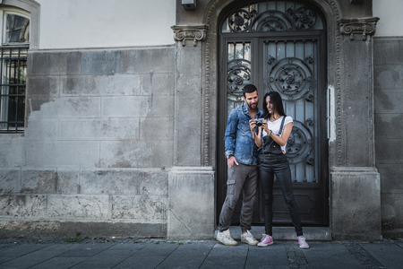 Girl showing camera to her boyfriend in the cityの写真素材