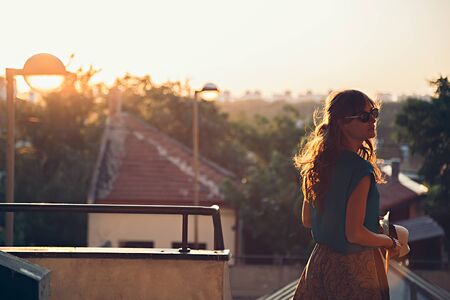 Girl walking and turning in fromt of a view. Sunsetの写真素材