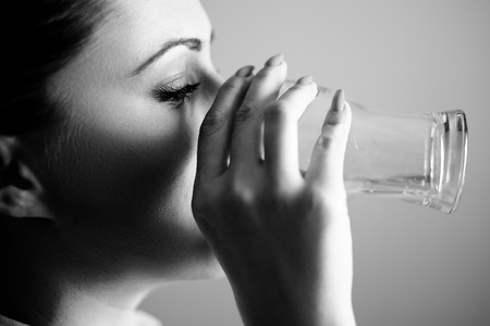 Girl drinking water from the glass. Black and whiteの写真素材