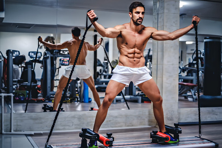 Man trains on slider in the gymの写真素材