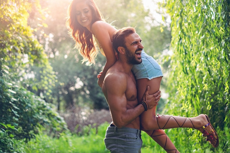 Man lifting his girl up and they are both laughingの写真素材