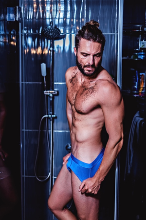 Man entering bathtub for a shower and a scrubの写真素材