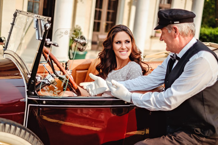 Old driver talking to a girl driver in a classic carの写真素材