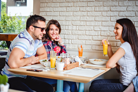 Friends laughing at the lunch in the restaurantの写真素材