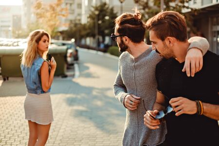 Male friends looking at the sexy girl walking in the street