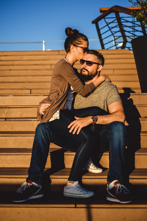Girlfriend sitting in her boyfriend lap and kissing him. They are siting on the stairsの写真素材