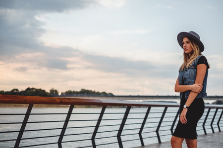 Hipster girl watching sunset by the river alone and sadの写真素材
