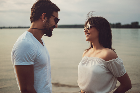 Smiling couple in love looking at each other by the riverの写真素材