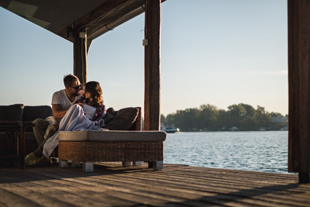 Smiling couple looking at each other by the riverr. Beautiful autumn dayの写真素材