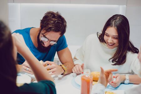 Beautiful brunette girl is laughnig while on the lunch with friendsの写真素材