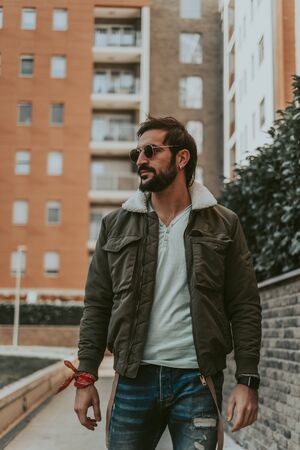 Handsome, stylish, bearded man walking alone in teh city