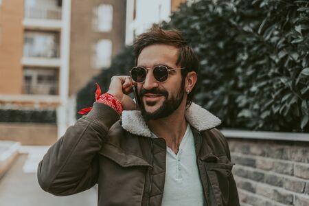 Portrait of a urban, smiling man talking on the phoneの写真素材