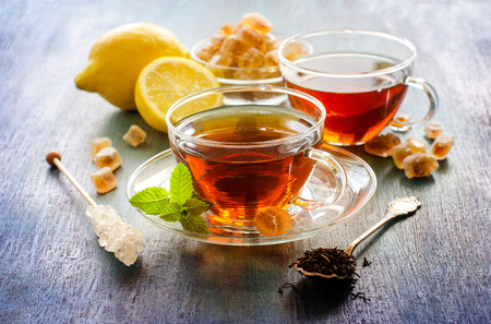 Cup of tea with mint and chrystal sugar on dark rustic background, hot drinks, teatimeの写真素材