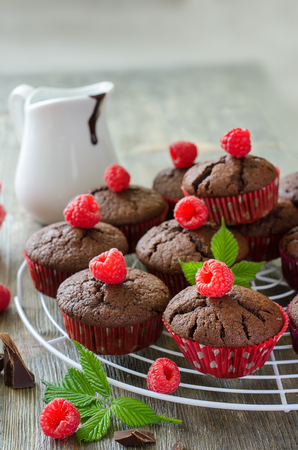 Chocolate delicious brown muffins with raspberries, homemade dessert, sweet foodの写真素材