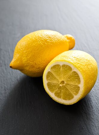 Yellow lemons on a slate boardの写真素材